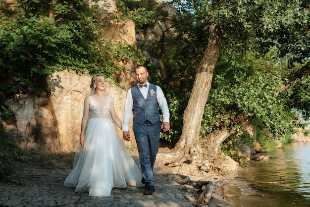 Bride blonde girl and groom near the river