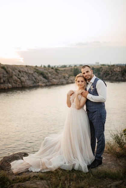Bride blonde girl and groom near the river