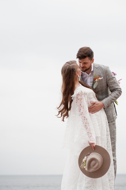 Photo bride and bridegroom standing against clear sky