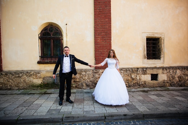 Bride and bridegroom walking across cobbled street