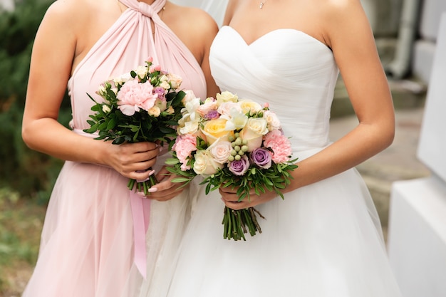 Bride and bridesmaid holding wedding bouquets