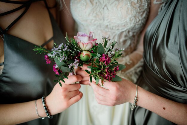 Невесты и подружки невесты держат в руках нежную бутоньерку