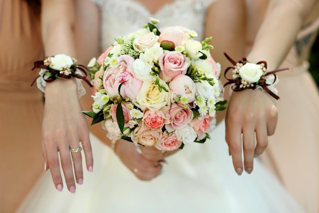 Bride and bridesmaids holding with wedding bouquets on their hands