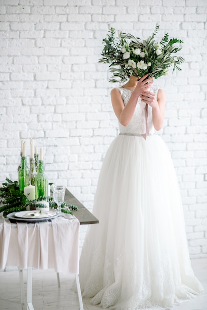 The bride covers her face with a bouquet