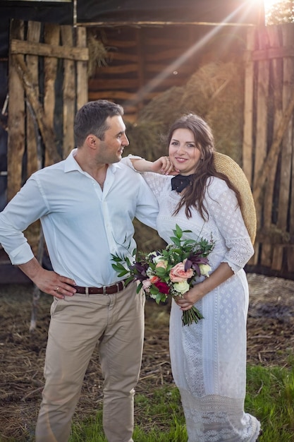 Bride in cowboy style sits on threshold of hayloftRustic wedding in the style of boho at the ranch