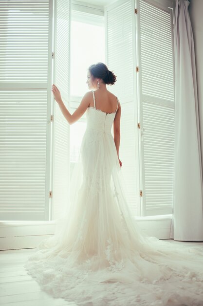  bride in dress near window