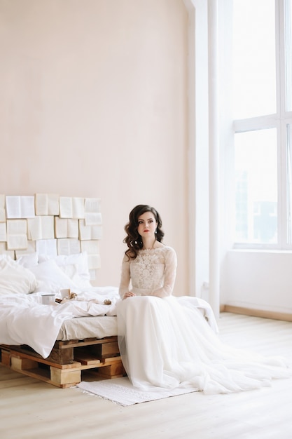 Photo bride in elegant classic wedding dress. beautiful girl portrait. morning wedding gatherings. tenderness concept.