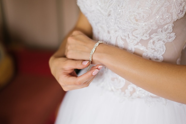 Bride fastens bracelet on her hand