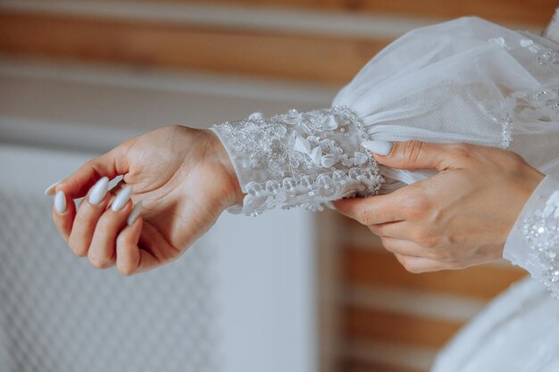 Foto la sposa fissa le maniche del suo vestito da sposa la sposa si prepara per il giorno delle nozze