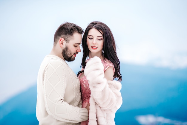 A bride in a fur coat with a fiance among the Carpathian mountains