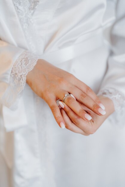 The bride gently touches her dear engagement ring