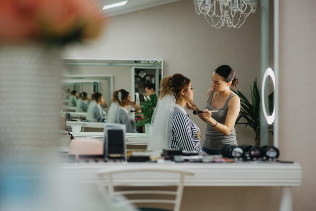 Photo the bride getting her makeup done in the mirror