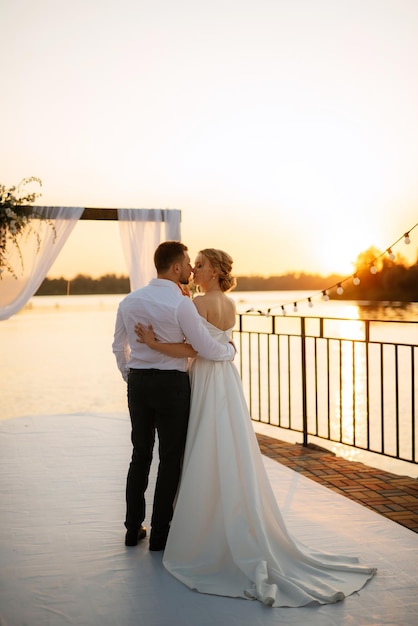 Bride and groom against the backdrop of a yellow sunset