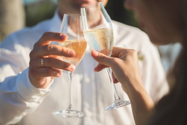 Bride and groom are holding champagne glasses