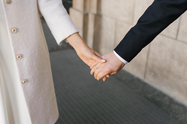 신부와 신랑은 부부의 성 발렌타인 데이에 손을 잡고 있습니다.