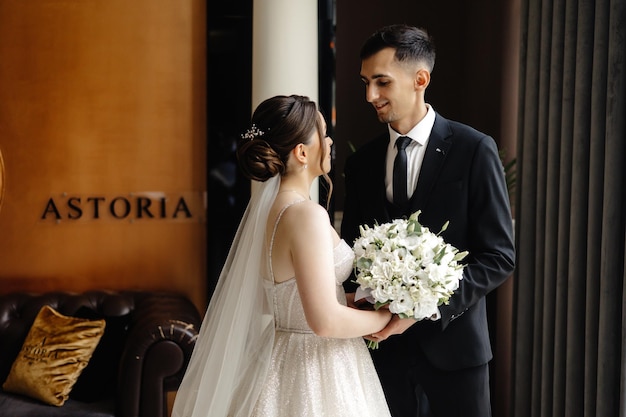 a bride and groom are looking at each other in front of a building