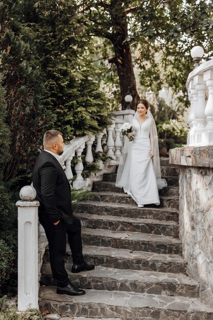 Photo a bride and groom are standing on a set of stairs