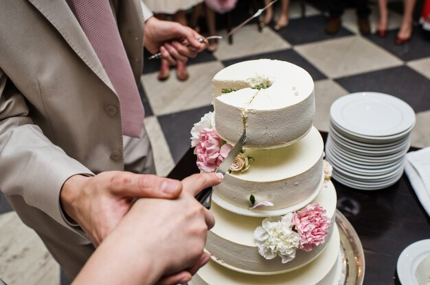 The bride and groom cut the wedding cake at a Banquet in a restaurant