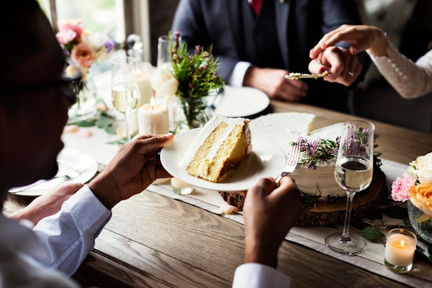 結婚式のレセプションでケーキを切る花嫁と花婿