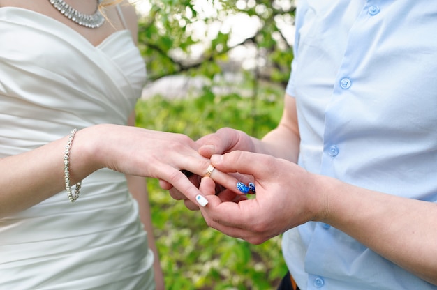 Bride groom dresses a wedding ring on her finger