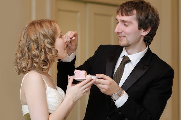 Sposa e sposo che mangiano la loro dolce torta nuziale