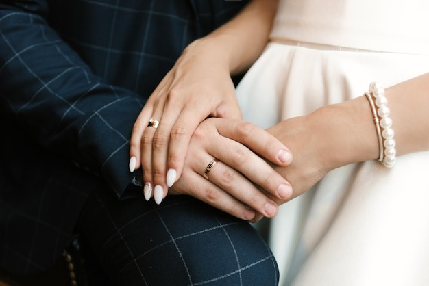 The bride and groom embrace hands closeup