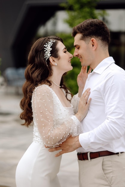 A bride and groom embrace and look at each other.