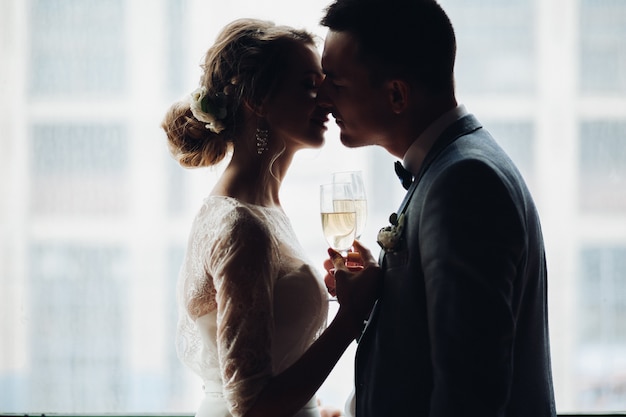 Bride and groom embracing and holding by hands each other