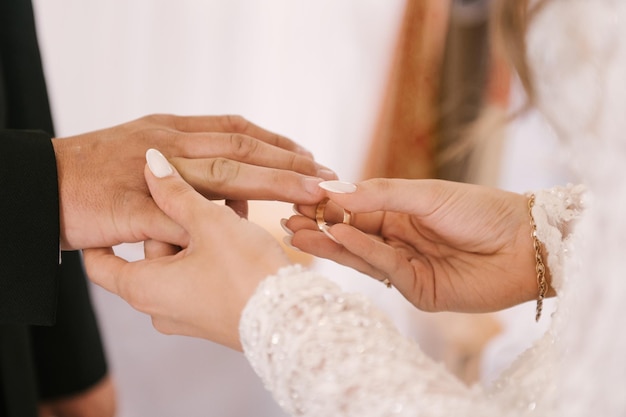 新郎新婦は教会で指輪を交換し、結婚式の秘跡