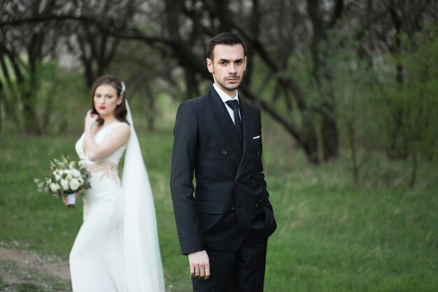 Bride and groom in the green forest