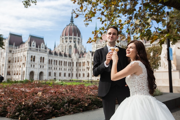 Bride and groom have fun and eating ice cream. 