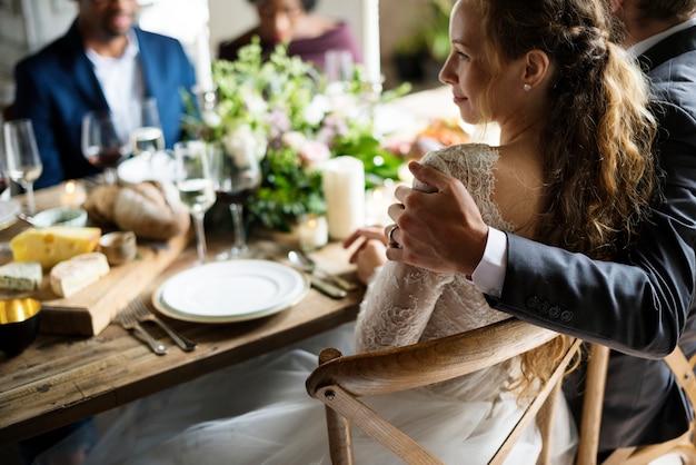 Foto sposa e sposo che hanno il pasto con gli amici al ricevimento di nozze