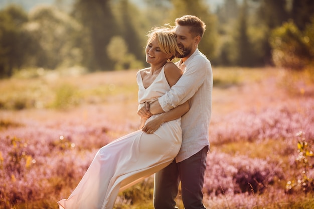 Bride and groom hold each other hands across the field