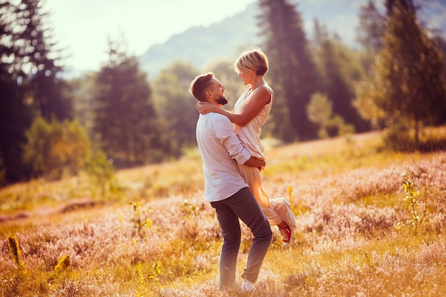 Bride and groom hold each other hands whirling on the field