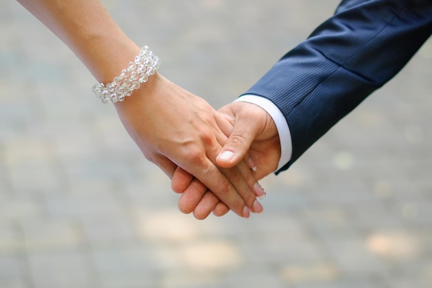 The bride and groom hold each other's hands