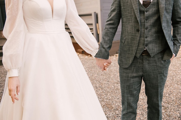 The bride and groom hold hands