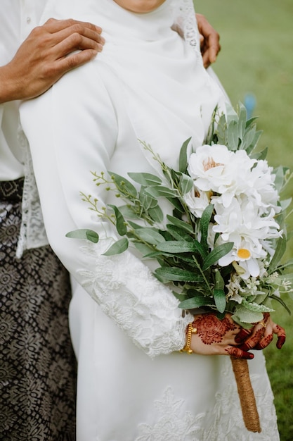 The bride and groom holding a bouquet of flowers.