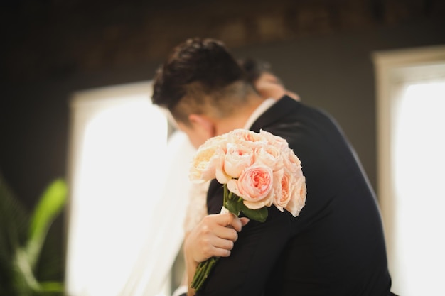 Bride and groom holding a bouquet of roses