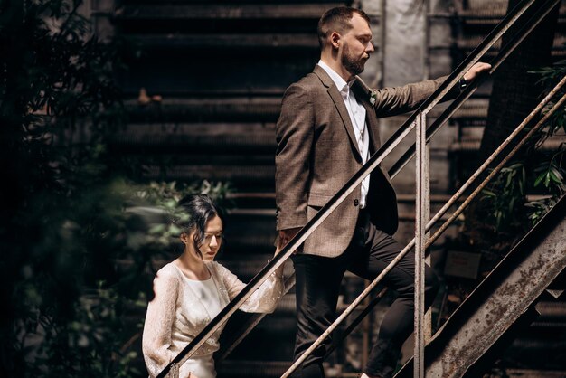 Bride and groom holding by hand going upstairs