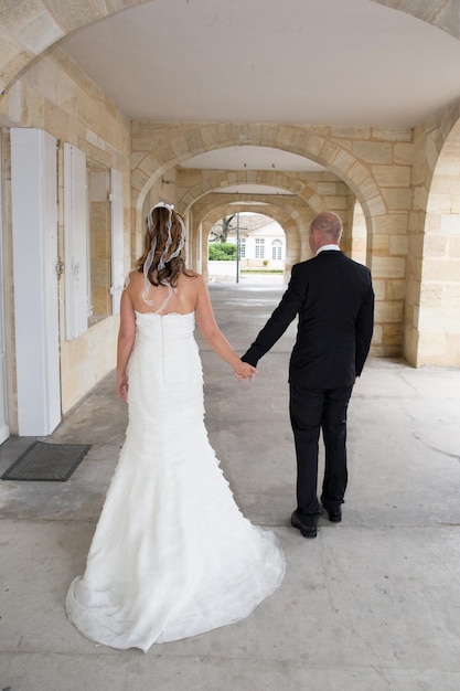 Photo bride and groom holding hands in the city