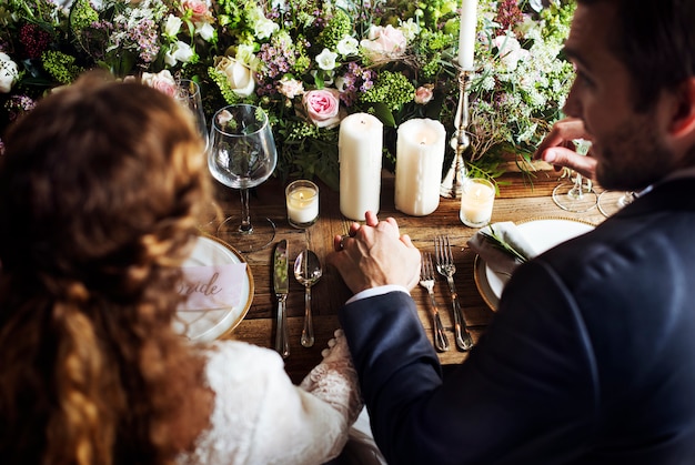 Foto sposa e sposo che si tengono per mano sul ricevimento di nozze