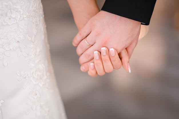 Photo bride and groom holding hands outdoors