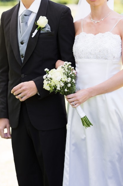 Bride and groom holding hands in park