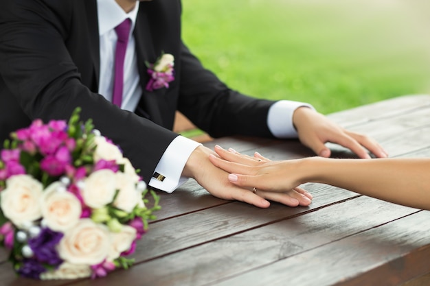 bride and groom holding hands on a table