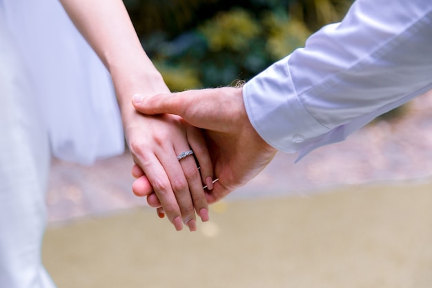 Photo bride and groom holding hands in wedding celemony.