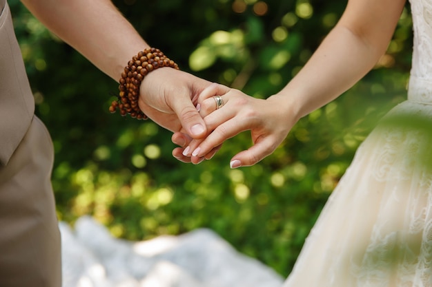 Жених и невеста держатся за руки в день свадьбы