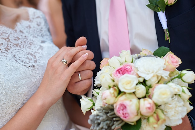 Bride and groom holding hands with bridal bouquet