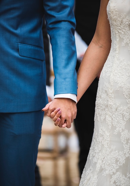 Bride and groom holding hands with love