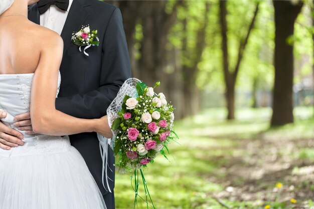 Bride and groom holding stylish bouquet during wedding ceremony