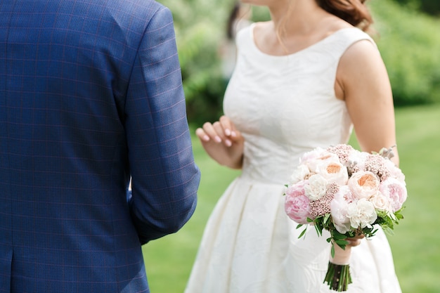 結婚式の花束を保持している新郎新婦